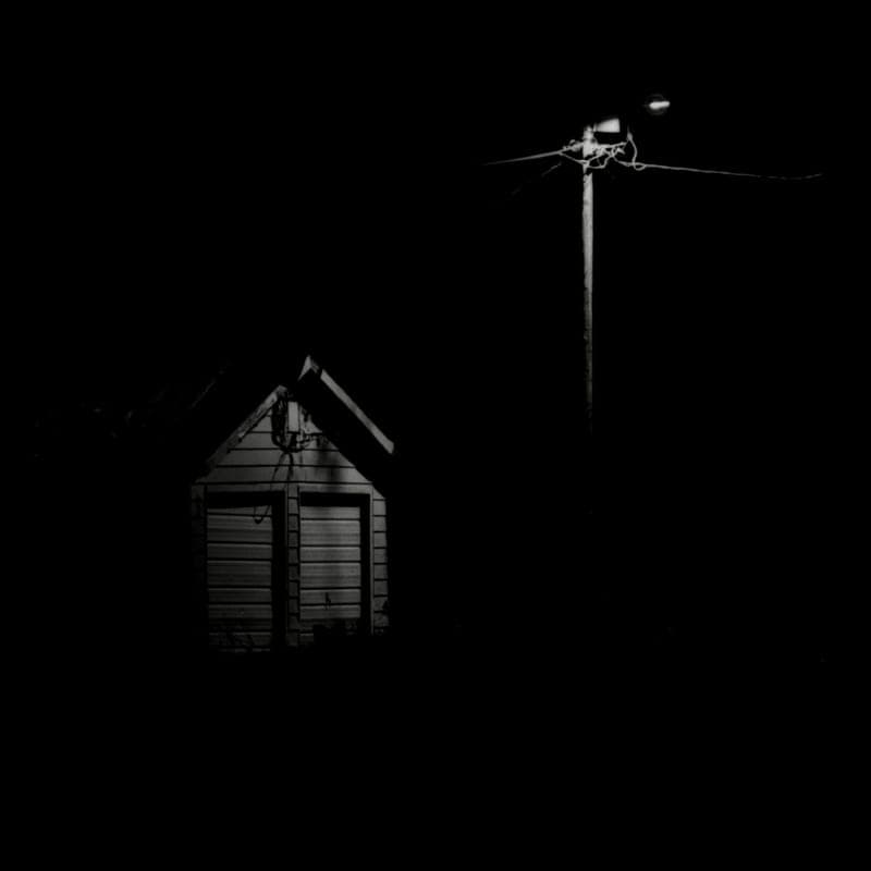 Projected light across the front of a house at night